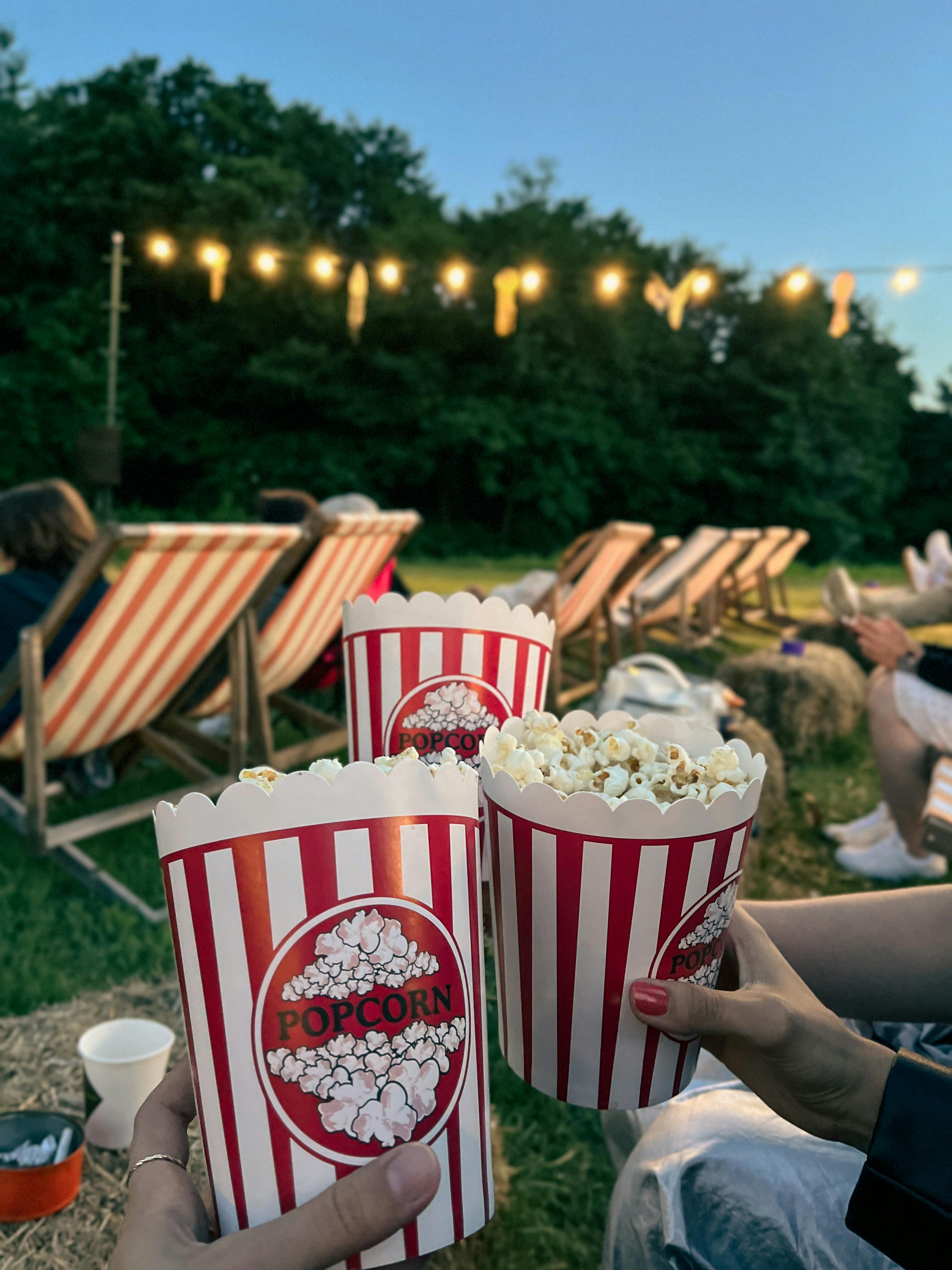 people holding popcorn buckets