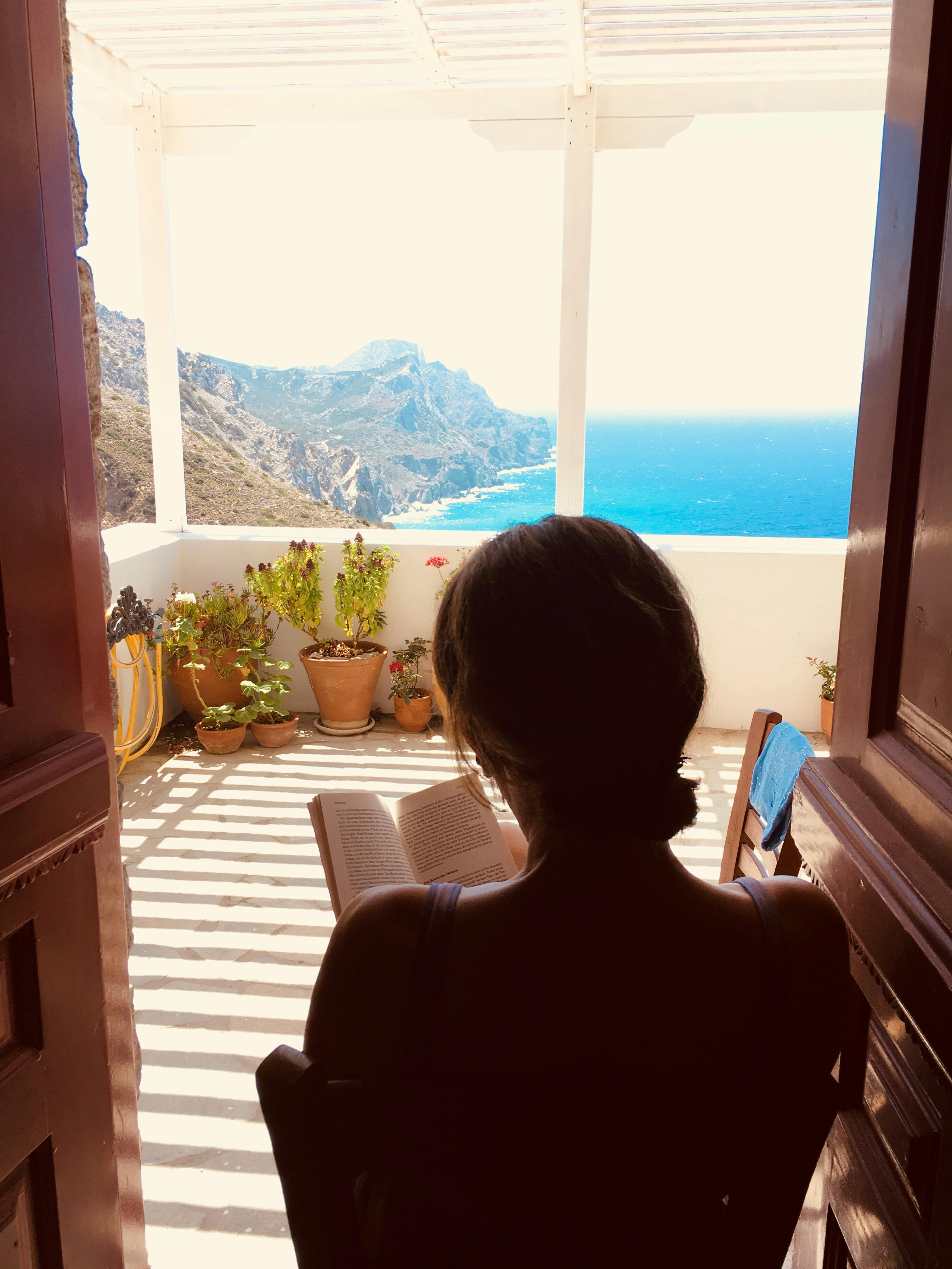 woman reading a book on a balcony